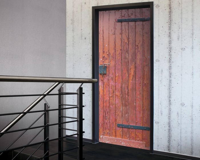 Ein Foto von der selbstklebenden Türtapete Alte rote Tür einer Scheune tapeziert auf einer Tür. Bestelle Deine Türtapete online.