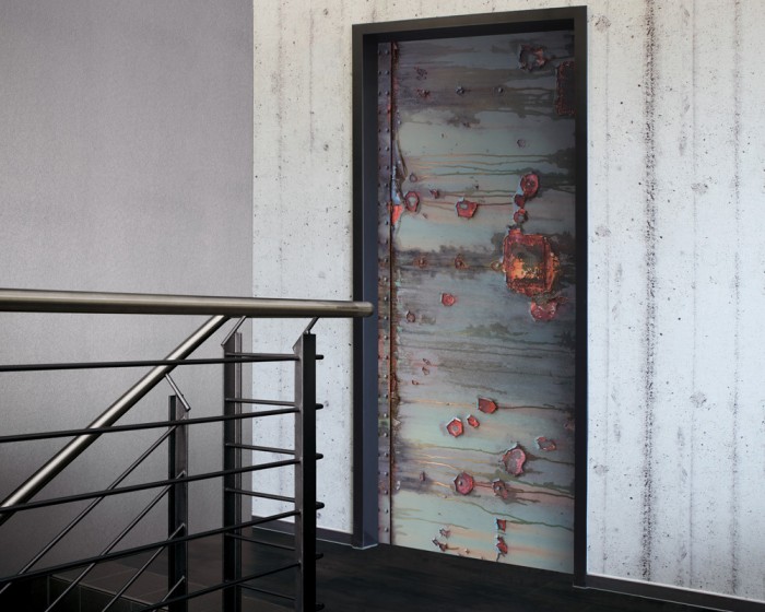 Ein Foto von der selbstklebenden Türtapete Altes Metall, Rostwand tapeziert auf einer Tür. Bestelle Deine Türtapete online.