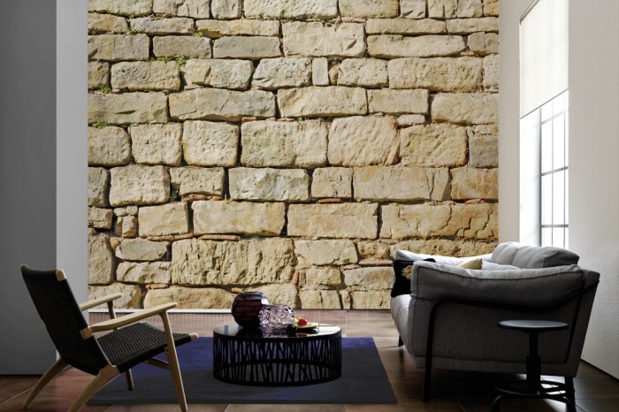 Im Wohnzimmer die Fototapete Stein Wand, Burgmauer Sand auf einer großen Wand tapeziert. Die Fototapete Stein Wand, Burgmauer Sand ist als Vlies-Fototapete im Wohnzimmer leicht zu tapezieren.