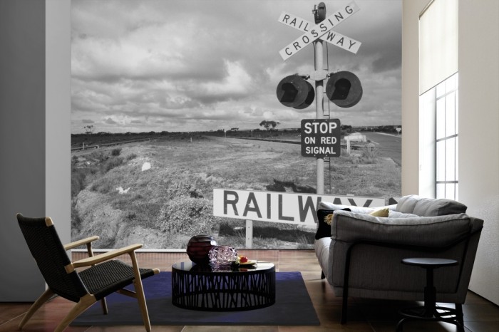 Im Wohnzimmer die Fototapete Bahnübergang, schwarz-weiß auf einer großen Wand tapeziert. Die Fototapete Bahnübergang, schwarz-weiß ist als Vlies-Fototapete im Wohnzimmer leicht zu tapezieren.