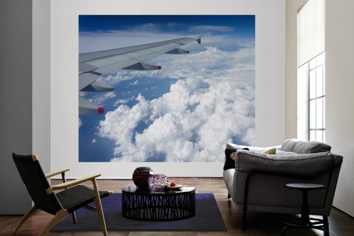 Die Fototapete Über den Wolken 2 als große Bildtapete im Wohnzimmer. Als Bildtapete ist die Fototapete Über den Wolken 2 ein besonderes Highlight auf Vliestapete.