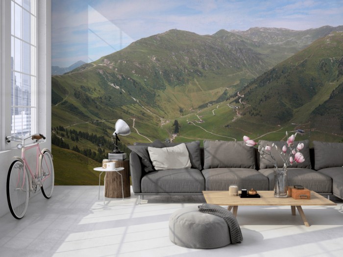 Die Fototapete Alpen Österreich, Grünes Tal auf einer großen Wand im Loft tapeziert. Die Fototapete Alpen Österreich, Grünes Tal wird individuell auf Deine Wand angepasst.