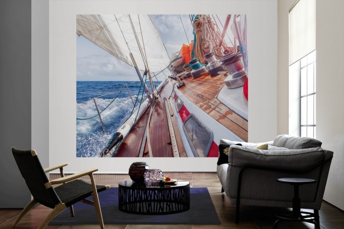 Die Fototapete Segelboot im Meer als große Bildtapete im Wohnzimmer. Als Bildtapete ist die Fototapete Segelboot im Meer ein besonderes Highlight auf Vliestapete.