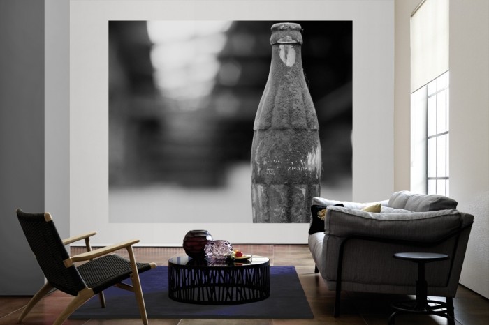 Die Fototapete Coke Flasche, schwarz-weiß als große Bildtapete im Wohnzimmer. Als Bildtapete ist die Fototapete Coke Flasche, schwarz-weiß ein besonderes Highlight auf Vliestapete.