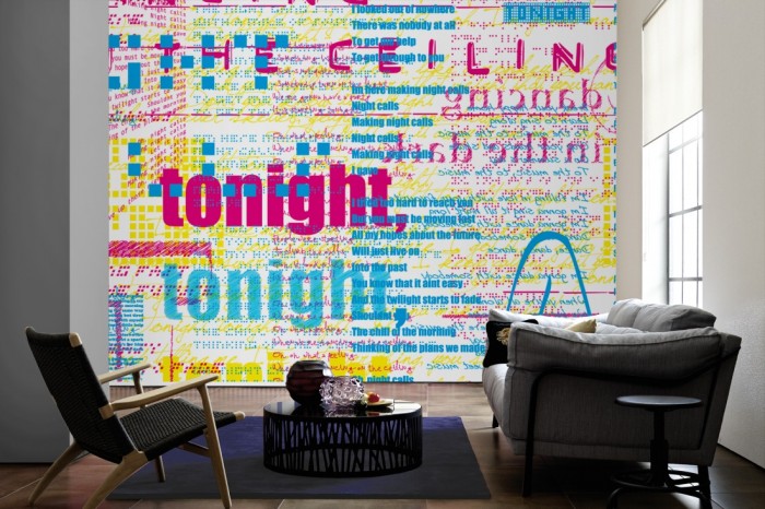 Im Wohnzimmer die Designer-Fototapete Chamäleon-Effekt Schriften auf einer großen Wand tapeziert. Die Designer-Fototapete Chamäleon-Effekt Schriften ist als Vlies-Fototapete im Wohnzimmer leicht zu tapezieren.