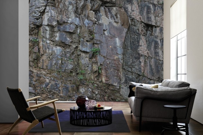 Im Wohnzimmer die Fototapete Felswand, graue Steilwand auf einer großen Wand tapeziert. Die Fototapete Felswand, graue Steilwand ist als Vlies-Fototapete im Wohnzimmer leicht zu tapezieren.