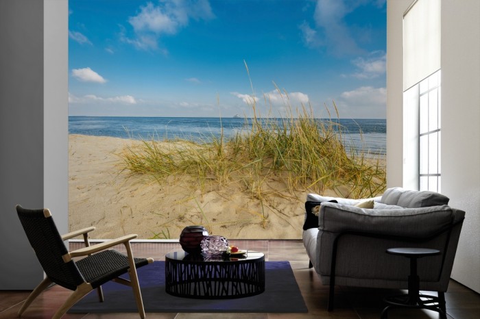 Im Wohnzimmer die Fototapete Sylt, Düne am Meer bei Sonnenschein auf einer großen Wand tapeziert. Die Fototapete Sylt, Düne am Meer bei Sonnenschein ist als Vlies-Fototapete im Wohnzimmer leicht zu tapezieren.