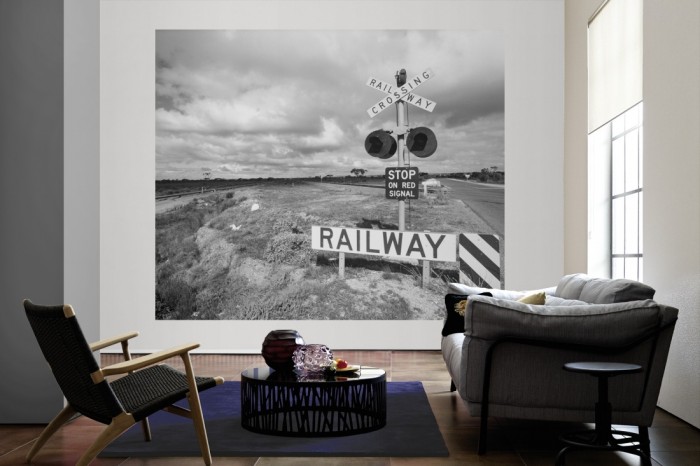 Die Fototapete Bahnübergang, schwarz-weiß als große Bildtapete im Wohnzimmer. Als Bildtapete ist die Fototapete Bahnübergang, schwarz-weiß ein besonderes Highlight auf Vliestapete.