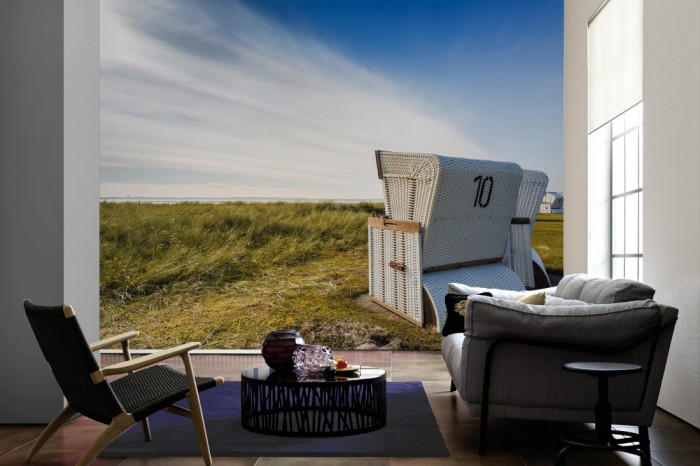 Im Wohnzimmer die Fototapete Sylt, Strandkorb in den Dünen auf einer großen Wand tapeziert. Die Fototapete Sylt, Strandkorb in den Dünen ist als Vlies-Fototapete im Wohnzimmer leicht zu tapezieren.