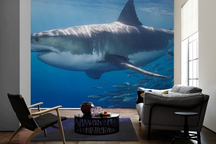Im Wohnzimmer die Fototapete Hai mit Fischschwarm auf einer großen Wand tapeziert. Die Fototapete Hai mit Fischschwarm ist als Vlies-Fototapete im Wohnzimmer leicht zu tapezieren.
