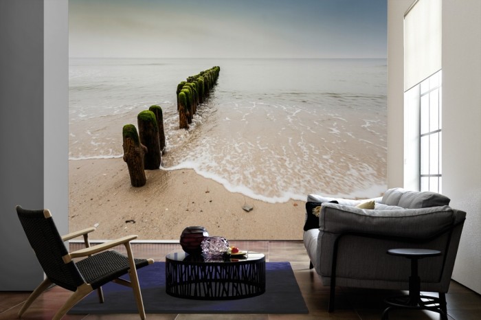 Im Wohnzimmer die Fototapete Strand der Nordsee, Wellenbrecher auf einer großen Wand tapeziert. Die Fototapete Strand der Nordsee, Wellenbrecher ist als Vlies-Fototapete im Wohnzimmer leicht zu tapezieren.