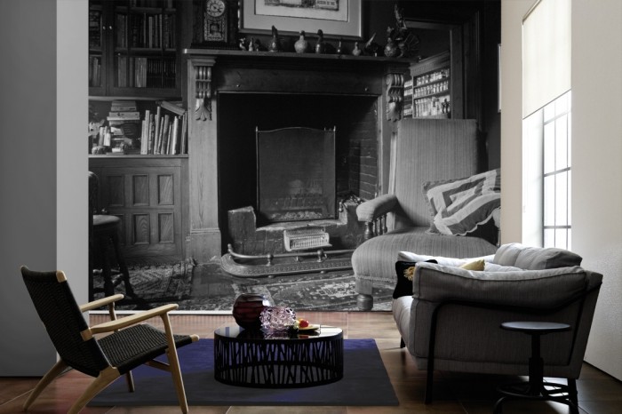 Im Wohnzimmer die Fototapete Wohnzimmer mit Kamin, schwarz-weiß auf einer großen Wand tapeziert. Die Fototapete Wohnzimmer mit Kamin, schwarz-weiß ist als Vlies-Fototapete im Wohnzimmer leicht zu tapezieren.