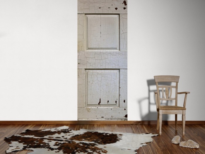 Ein Foto von dem 3D Fotopanel Alte Holztür in weiß tapeziert an der Wand. Bestelle Deine Bildtapete online.