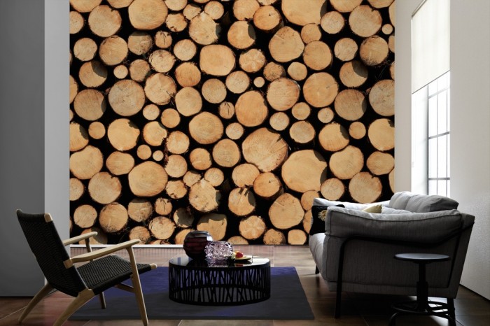 Im Wohnzimmer die Fototapete Holz Wand, Baumstämme auf einer großen Wand tapeziert. Die Fototapete Holz Wand, Baumstämme ist als Vlies-Fototapete im Wohnzimmer leicht zu tapezieren.
