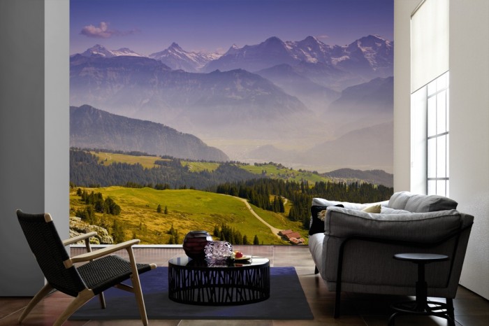 Im Wohnzimmer die Fototapete Berglandschaft in der Schweiz auf einer großen Wand tapeziert. Die Fototapete Berglandschaft in der Schweiz ist als Vlies-Fototapete im Wohnzimmer leicht zu tapezieren.