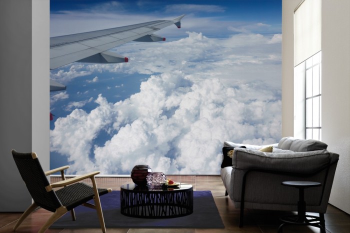 Im Wohnzimmer die Fototapete Über den Wolken 2 auf einer großen Wand tapeziert. Die Fototapete Über den Wolken 2 ist als Vlies-Fototapete im Wohnzimmer leicht zu tapezieren.