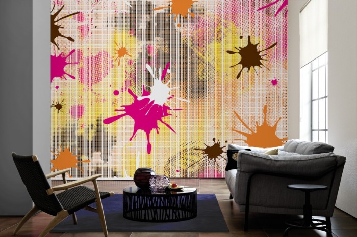 Im Wohnzimmer die Design-Fototapete Geometrie Splash Pink auf einer großen Wand tapeziert. Die Design-Fototapete Geometrie Splash Pink ist als Vlies-Fototapete im Wohnzimmer leicht zu tapezieren.