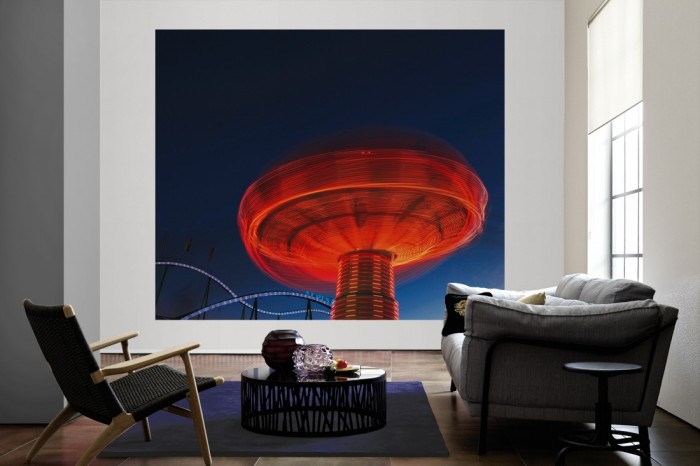 Die Fototapete Karussell in Bewegung, Oktoberfest in München als große Bildtapete im Wohnzimmer. Als Bildtapete ist die Fototapete Karussell in Bewegung, Oktoberfest in München ein besonderes Highlight auf Vliestapete.