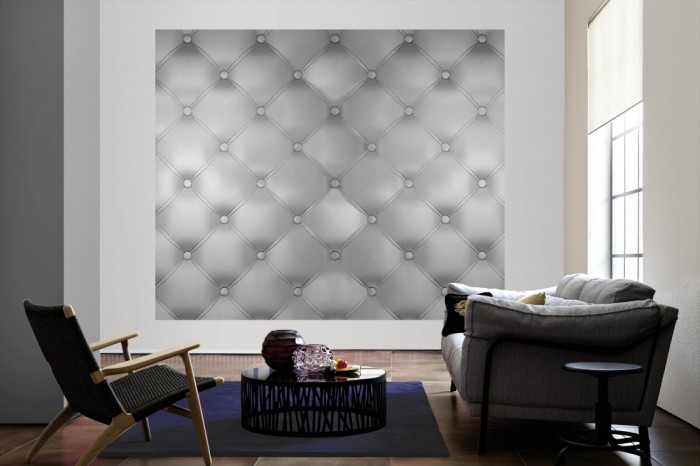 Die Design-Fototapete 3D-Effekt mit grauem Polster als große Bildtapete im Wohnzimmer. Als Bildtapete ist die Design-Fototapete 3D-Effekt mit grauem Polster ein besonderes Highlight auf Vliestapete.