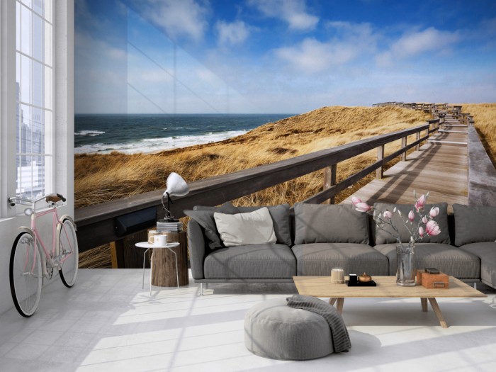 Die Fototapete Sylt, Holzsteg am Strand auf einer großen Wand im Loft tapeziert. Die Fototapete Sylt, Holzsteg am Strand wird individuell auf Deine Wand angepasst.
