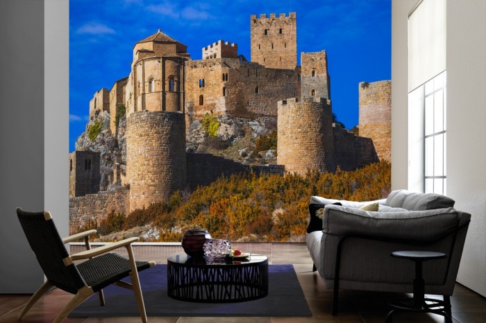 Im Wohnzimmer die Fototapete Burg im Sonnenschein, Castillo de Loarre auf einer großen Wand tapeziert. Die Fototapete Burg im Sonnenschein, Castillo de Loarre ist als Vlies-Fototapete im Wohnzimmer leicht zu tapezieren.
