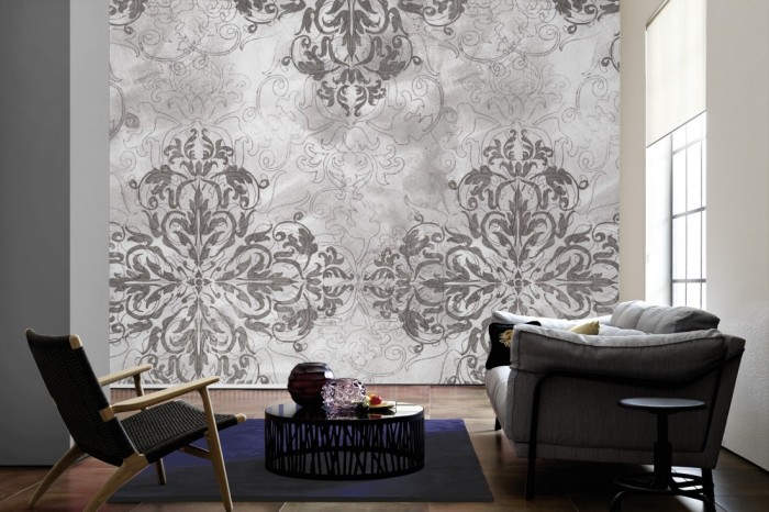 Im Wohnzimmer die Designtapete Barock Ornament, Vintage Grau auf einer großen Wand tapeziert. Die Designtapete Barock Ornament, Vintage Grau ist als Vlies-Fototapete im Wohnzimmer leicht zu tapezieren.