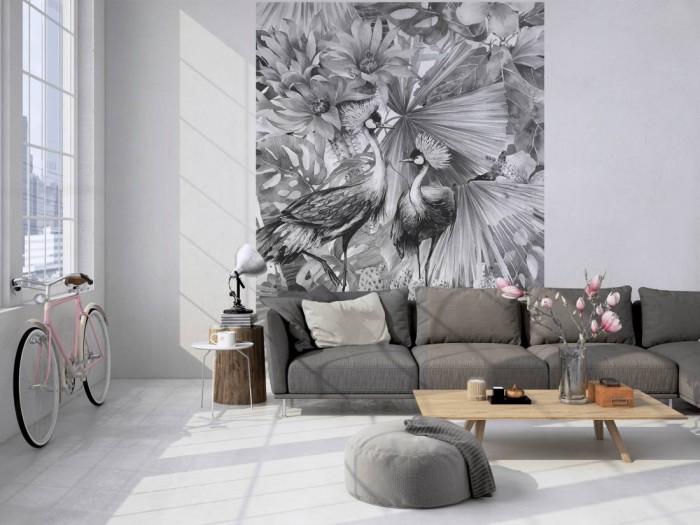 Das Design-Fotopanel Kraniche in Blüten und Blättern schwarz-weiß tapeziert in einem Loft. Bestelle die Bildtapete für Deine Wand online.
