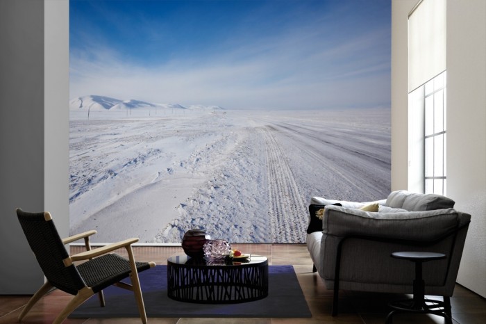 Im Wohnzimmer die Fototapete Eisstraße mit Schnee bedeckt auf einer großen Wand tapeziert. Die Fototapete Eisstraße mit Schnee bedeckt ist als Vlies-Fototapete im Wohnzimmer leicht zu tapezieren.