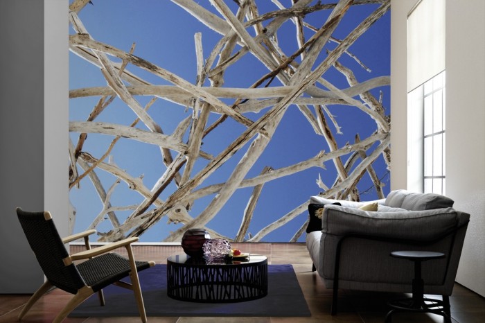 Im Wohnzimmer die Fototapete Holz mit Blick in den Himmel auf einer großen Wand tapeziert. Die Fototapete Holz mit Blick in den Himmel ist als Vlies-Fototapete im Wohnzimmer leicht zu tapezieren.