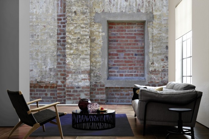 Im Wohnzimmer die Fototapete Ziegel Wand, altes Haus auf einer großen Wand tapeziert. Die Fototapete Ziegel Wand, altes Haus ist als Vlies-Fototapete im Wohnzimmer leicht zu tapezieren.