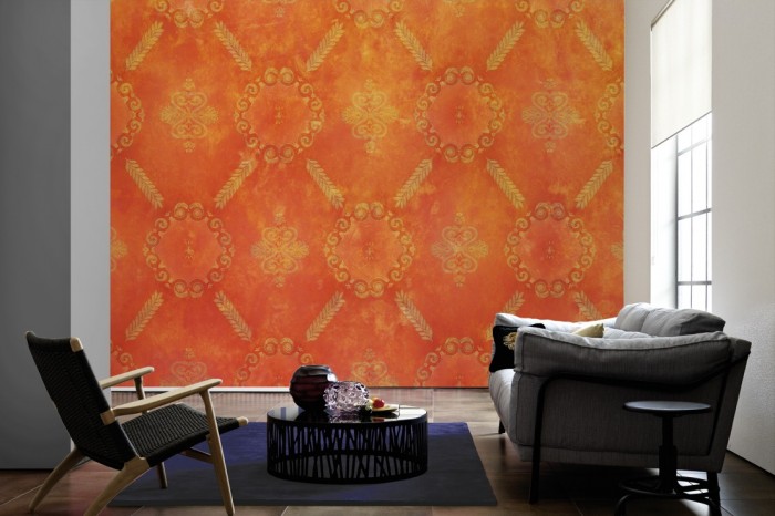 Im Wohnzimmer die Designtapete Barock Ornament, Vintage Orange auf einer großen Wand tapeziert. Die Designtapete Barock Ornament, Vintage Orange ist als Vlies-Fototapete im Wohnzimmer leicht zu tapezieren.