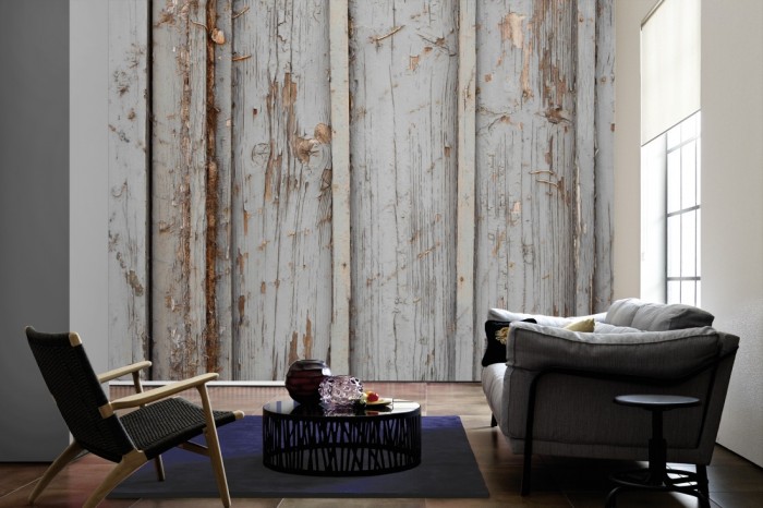 Im Wohnzimmer die Fototapete Holz Wand, grauer Anstrich auf einer großen Wand tapeziert. Die Fototapete Holz Wand, grauer Anstrich ist als Vlies-Fototapete im Wohnzimmer leicht zu tapezieren.