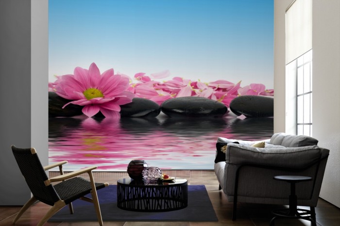 Im Wohnzimmer die Fototapete Wellness, Wellness-Steine mit rosa Kamille-Blüten auf einer großen Wand tapeziert. Die Fototapete Wellness, Wellness-Steine mit rosa Kamille-Blüten ist als Vlies-Fototapete im Wohnzimmer leicht zu tapezieren.