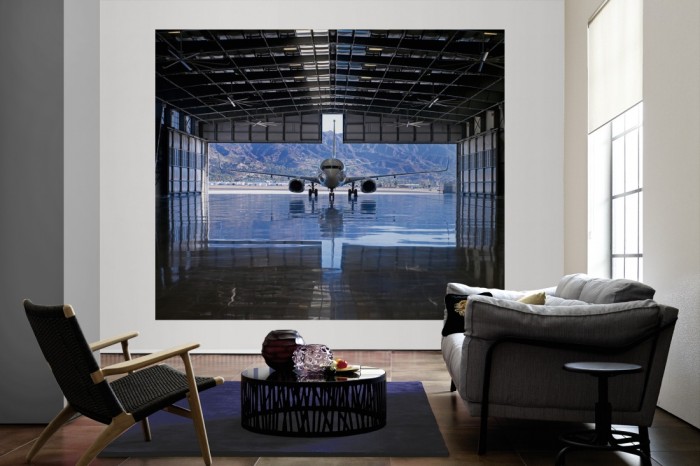 Die Fototapete Flugzeug im Hangar als große Bildtapete im Wohnzimmer. Als Bildtapete ist die Fototapete Flugzeug im Hangar ein besonderes Highlight auf Vliestapete.