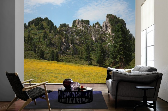 Im Wohnzimmer die Fototapete Alpen Österreich, Grüner Berg auf einer großen Wand tapeziert. Die Fototapete Alpen Österreich, Grüner Berg ist als Vlies-Fototapete im Wohnzimmer leicht zu tapezieren.