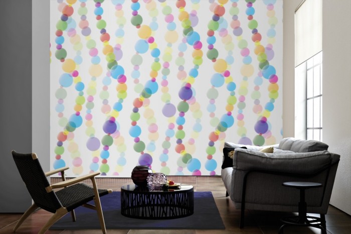 Im Wohnzimmer die Design-Fototapete 3D-Geometrie bunte Kugeln auf einer großen Wand tapeziert. Die Design-Fototapete 3D-Geometrie bunte Kugeln ist als Vlies-Fototapete im Wohnzimmer leicht zu tapezieren.