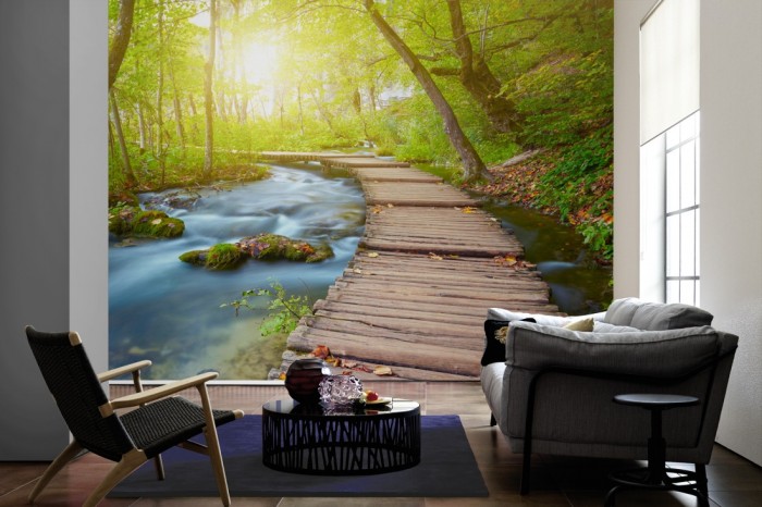 Im Wohnzimmer die Fototapete Holzsteg im Wald auf einer großen Wand tapeziert. Die Fototapete Holzsteg im Wald ist als Vlies-Fototapete im Wohnzimmer leicht zu tapezieren.