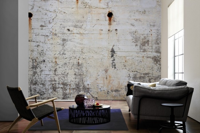 Im Wohnzimmer die Fototapete Beton Wand, alte Betonplanken auf einer großen Wand tapeziert. Die Fototapete Beton Wand, alte Betonplanken ist als Vlies-Fototapete im Wohnzimmer leicht zu tapezieren.