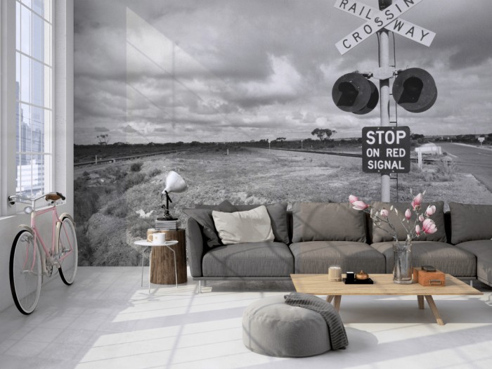 Die Fototapete Bahnübergang, schwarz-weiß auf einer großen Wand im Loft tapeziert. Die Fototapete Bahnübergang, schwarz-weiß wird individuell auf Deine Wand angepasst.