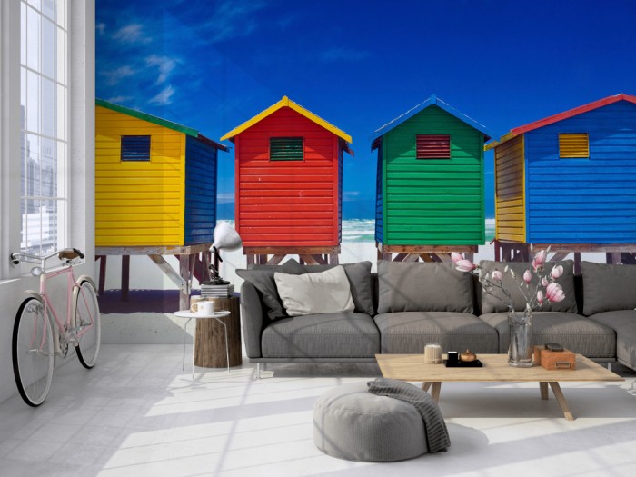 Die Fototapete Bunte Strandhäuser in Südafrika, Muizenberg auf einer großen Wand im Loft tapeziert. Die Fototapete Bunte Strandhäuser in Südafrika, Muizenberg wird individuell auf Deine Wand angepasst.