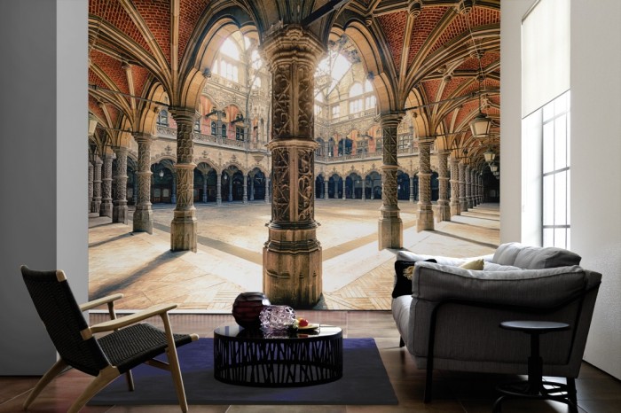 Im Wohnzimmer die Fototapete Antwerpener Börse aus dem 19. Jahrhundert auf einer großen Wand tapeziert. Die Fototapete Antwerpener Börse aus dem 19. Jahrhundert ist als Vlies-Fototapete im Wohnzimmer leicht zu tapezieren.