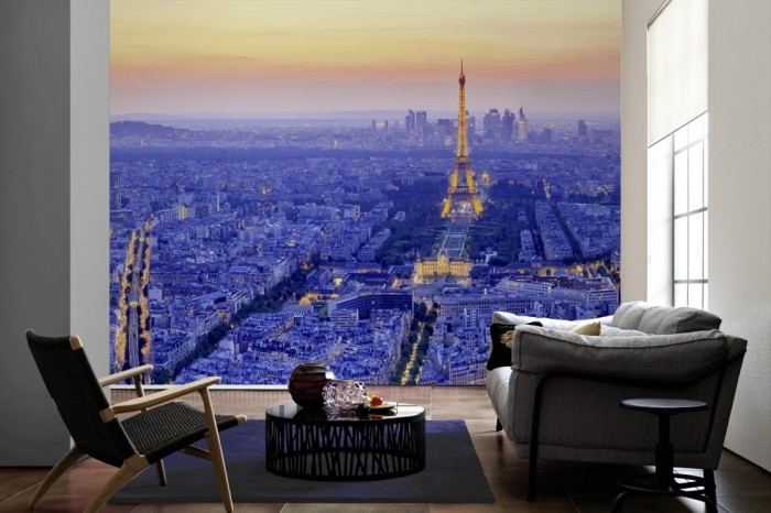 Im Wohnzimmer die Fototapete Paris Panorama bei Sonnenuntergang auf einer großen Wand tapeziert. Die Fototapete Paris Panorama bei Sonnenuntergang ist als Vlies-Fototapete im Wohnzimmer leicht zu tapezieren.