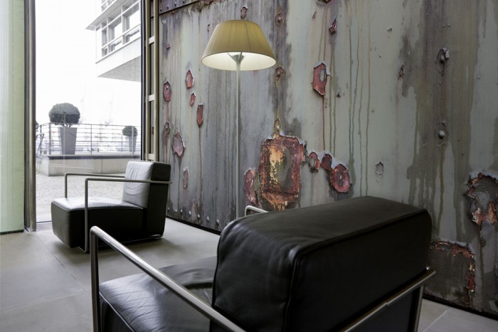 Im Wohnzimmer die Fototapete Altes Metall, Rostwand auf einer großen Wand tapeziert. Die Fototapete Altes Metall, Rostwand ist als Vlies-Fototapete im Wohnzimmer leicht zu tapezieren.