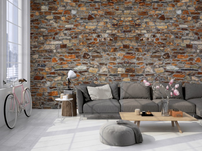 Die Fototapete Stein Wand, Naturstein rot-braun auf einer großen Wand im Loft tapeziert. Die Fototapete Stein Wand, Naturstein rot-braun wird individuell auf Deine Wand angepasst.