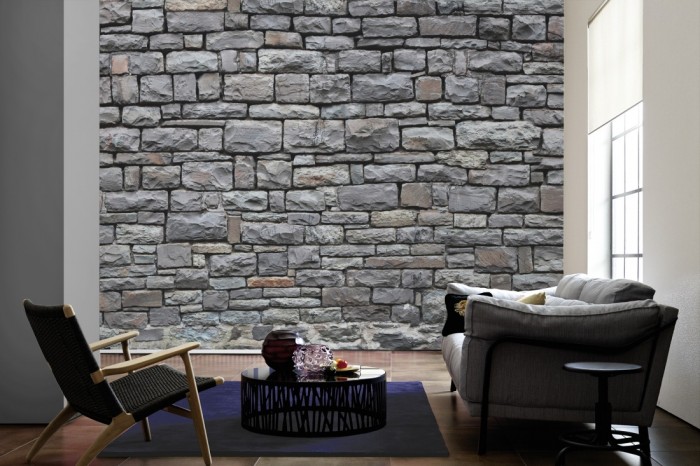 Im Wohnzimmer die Fototapete Stein Wand, Burgmauer auf einer großen Wand tapeziert. Die Fototapete Stein Wand, Burgmauer ist als Vlies-Fototapete im Wohnzimmer leicht zu tapezieren.