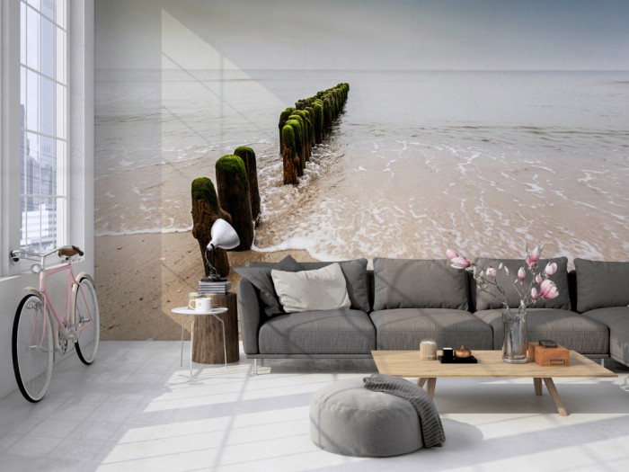 Die Fototapete Strand der Nordsee, Wellenbrecher auf einer großen Wand im Loft tapeziert. Die Fototapete Strand der Nordsee, Wellenbrecher wird individuell auf Deine Wand angepasst.