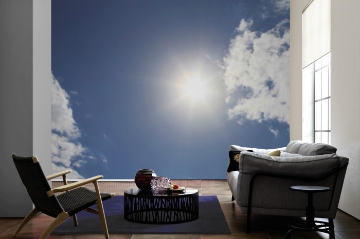 Im Wohnzimmer die Fototapete Sonnenhimmel mit Wolken auf einer großen Wand tapeziert. Die Fototapete Sonnenhimmel mit Wolken ist als Vlies-Fototapete im Wohnzimmer leicht zu tapezieren.