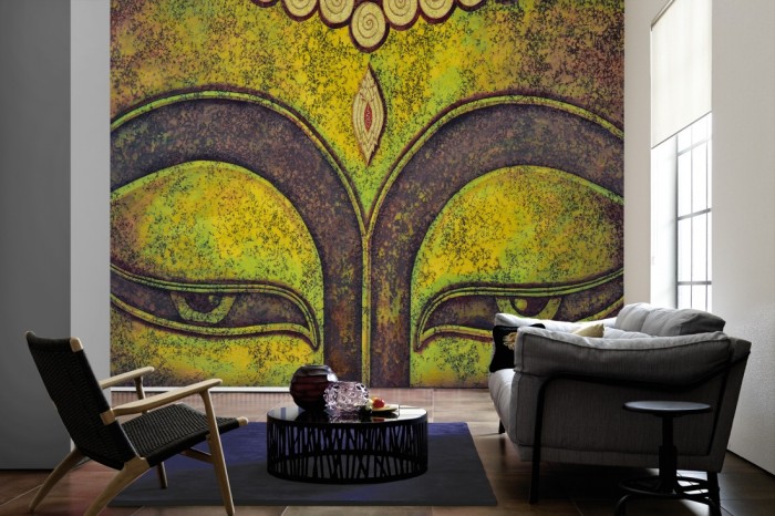 Im Wohnzimmer die Design-Fototapete Buddha Gesicht, Artwork auf einer großen Wand tapeziert. Die Design-Fototapete Buddha Gesicht, Artwork ist als Vlies-Fototapete im Wohnzimmer leicht zu tapezieren.