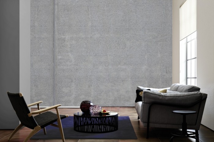 Im Wohnzimmer die Fototapete Beton Wand, Sichtbeton pur auf einer großen Wand tapeziert. Die Fototapete Beton Wand, Sichtbeton pur ist als Vlies-Fototapete im Wohnzimmer leicht zu tapezieren.