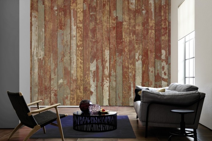 Im Wohnzimmer die Fototapete Holz Wand, alte Holzdielen in rot auf einer großen Wand tapeziert. Die Fototapete Holz Wand, alte Holzdielen in rot ist als Vlies-Fototapete im Wohnzimmer leicht zu tapezieren.